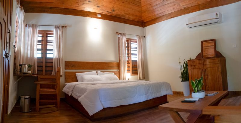 Room 01, with a timber ceiling, double bed and writing desk
