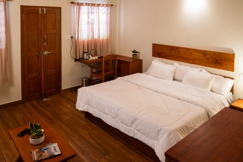Room 02, with wooden floors, a large bed and a teak headboard